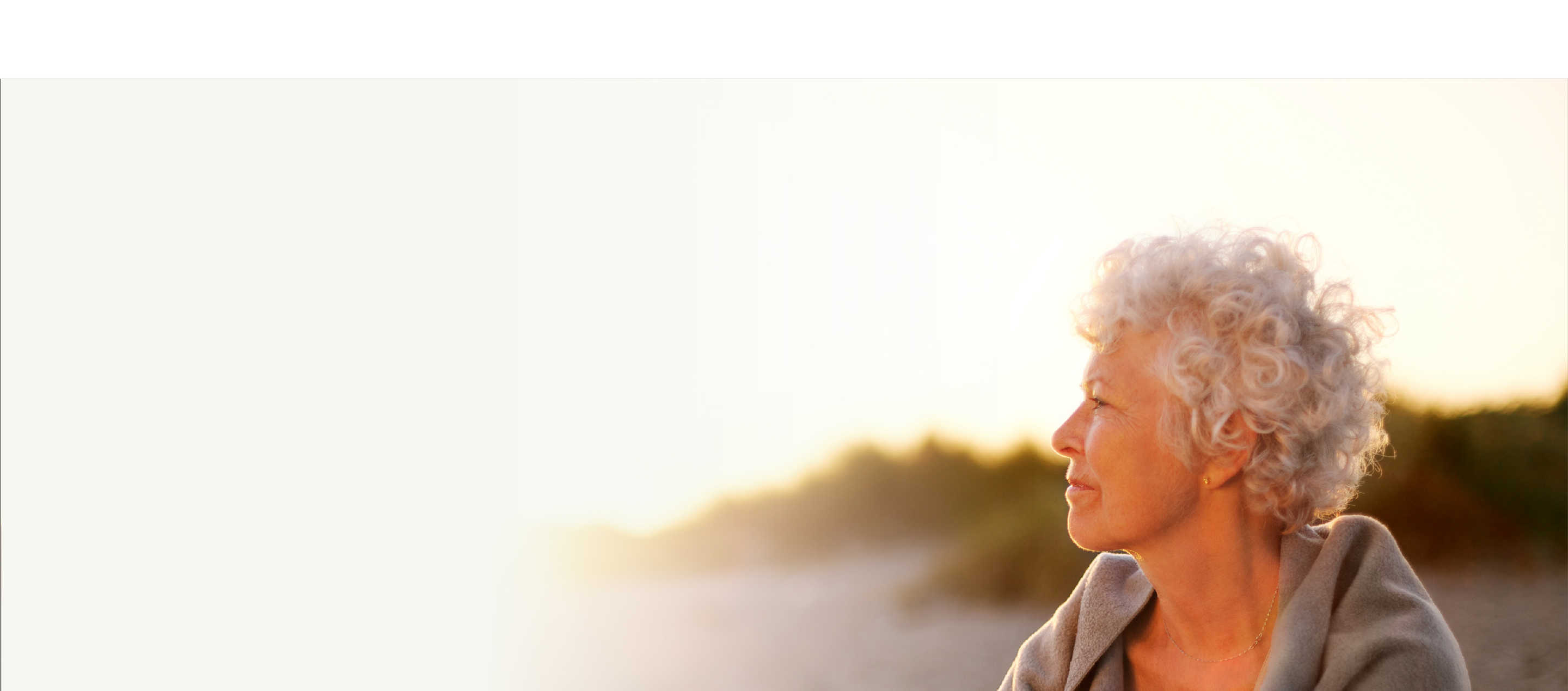 Living well hero, woman sitting on a beach