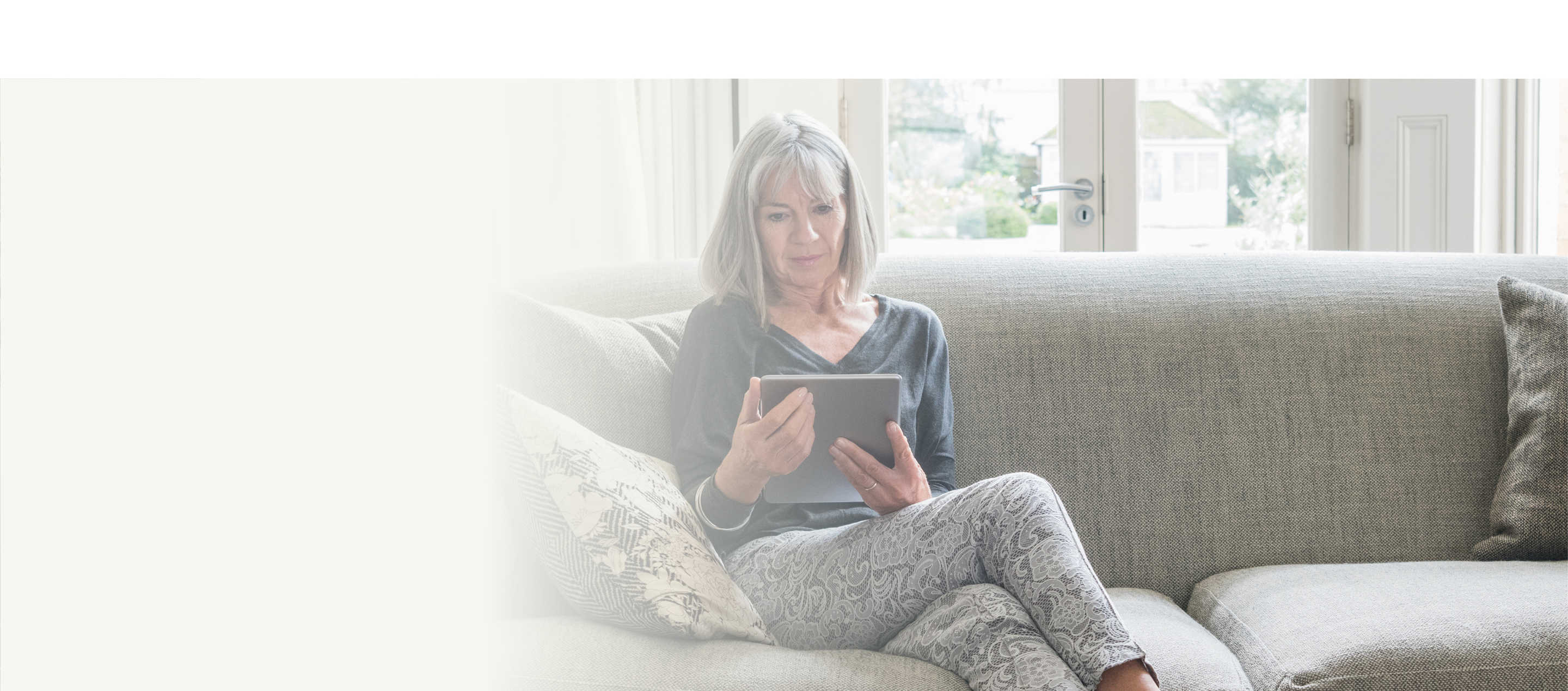 Resources hero, image showing a woman sitting on a sofa looking at a tablet