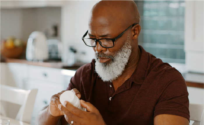How to take piqray, image of man holding pill bottle